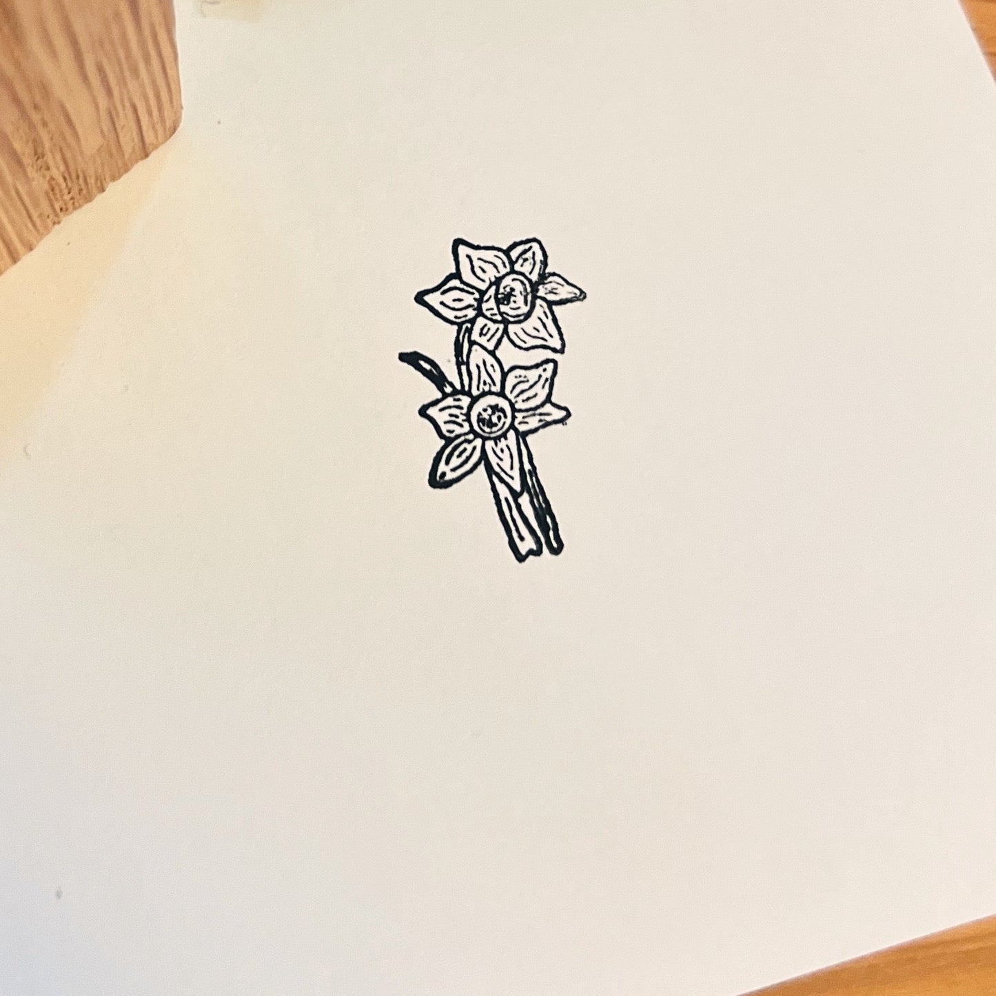 Close up of a black ink stamped daffodil on white paper