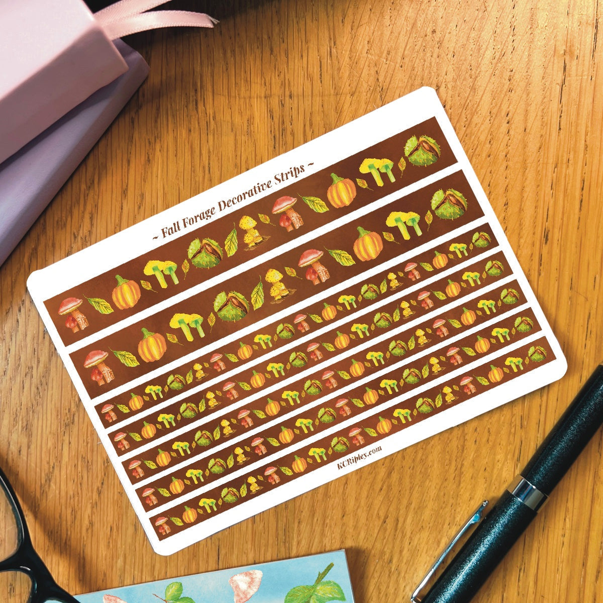 White sticker sheet with 2 wide and 5 narrow sticker strips in a warm brown with a repeating botanical pattern featuring mushrooms, conker, and pumpkins