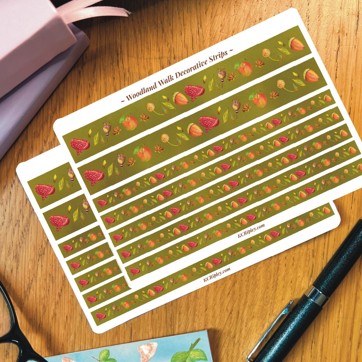 2 White sticker sheets with 2 wide and 5 narrow sticker strips in a moss green with a repeating botanical pattern featuring pomegranates, acorns, seeds and apples