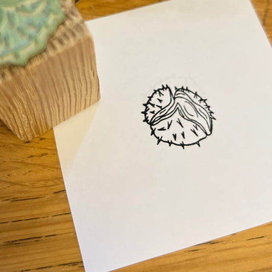 Close up of a black ink conker stamped on white paper