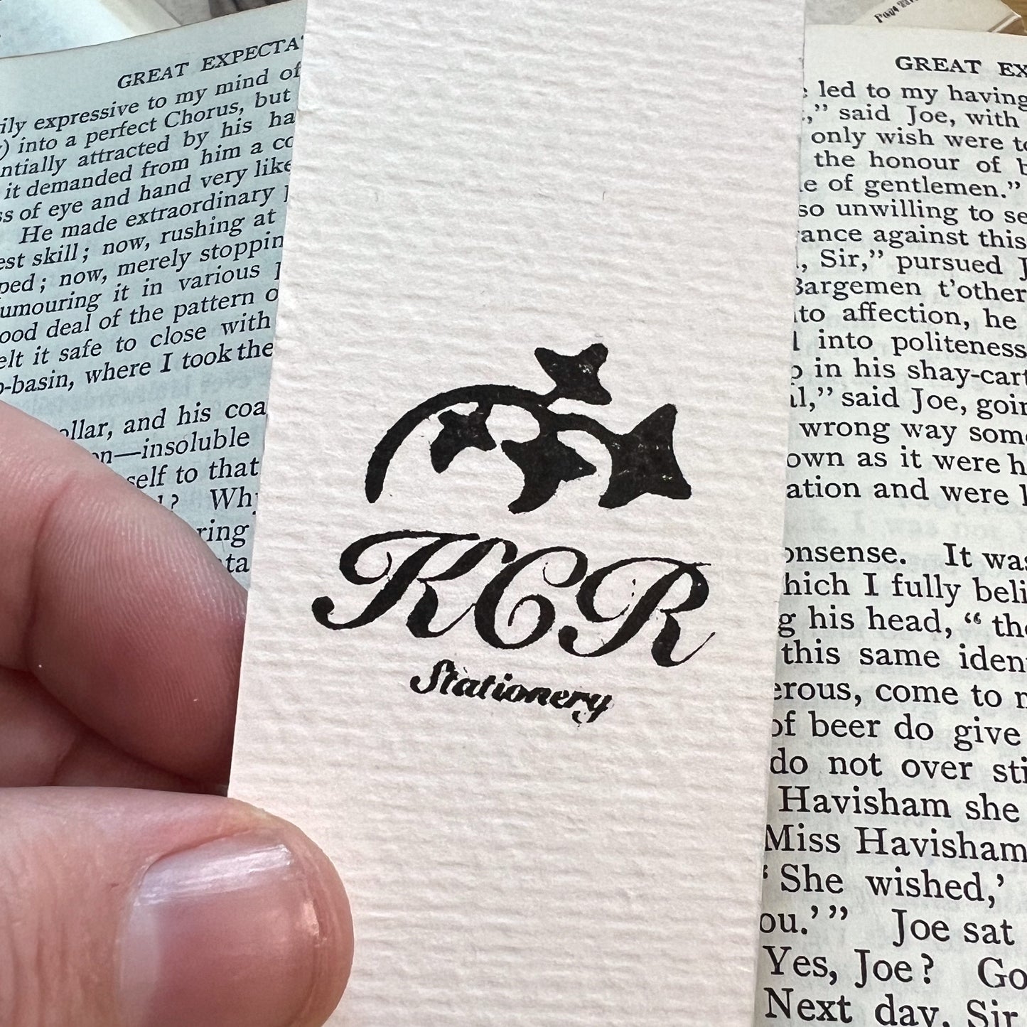 Close up of the back of bookmark showing white soft textured card with KCR Stationery stamped in black ink