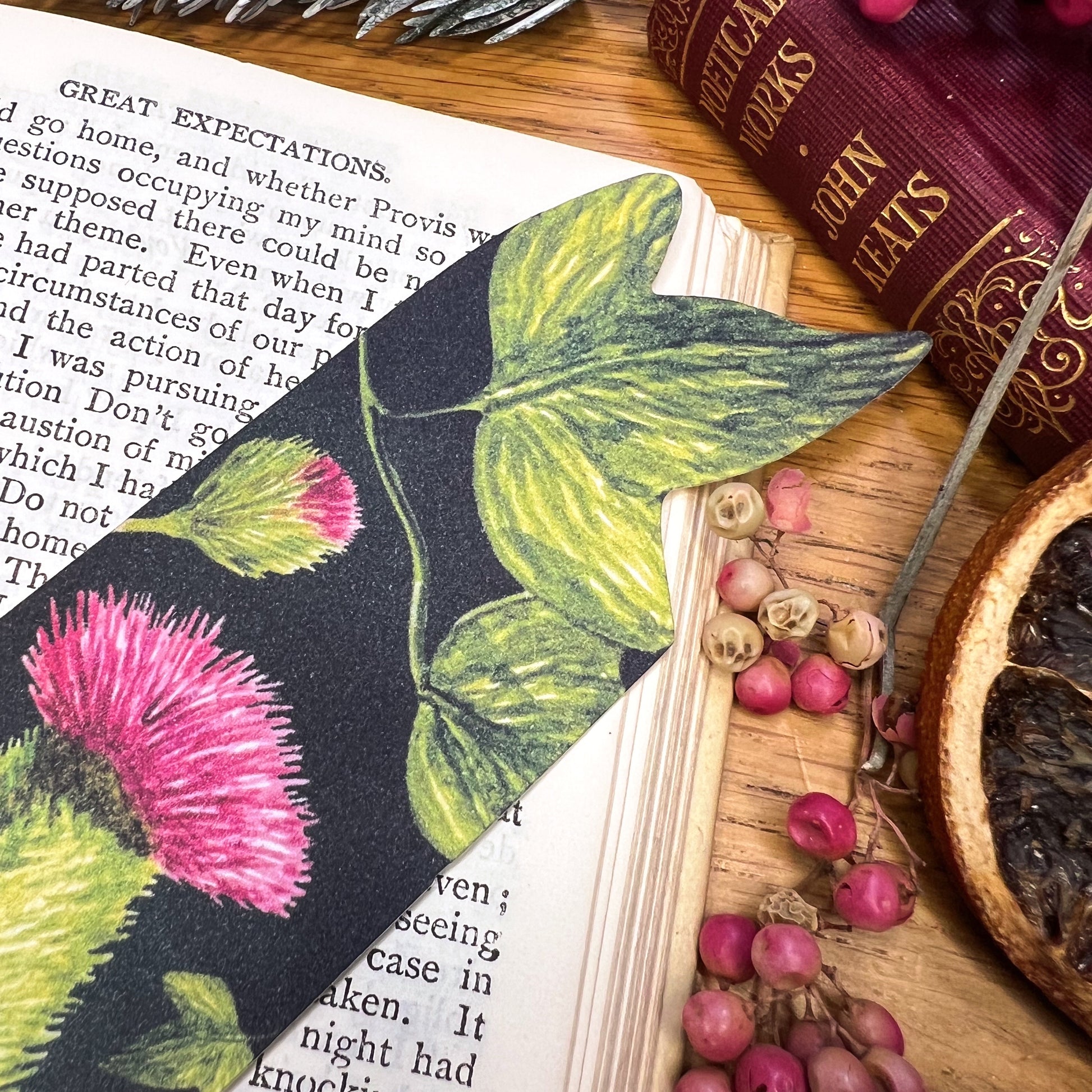 Close up of Winters bloom thistle and ivy illustrated bookmark cut at the top to the shape of the ivy leaf